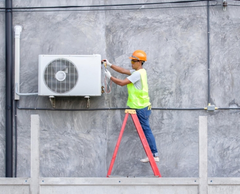 Worker changing parts on HVAC unit