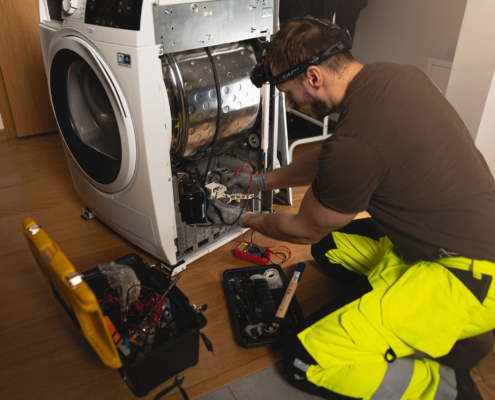 Repair person working on fixing a dryer