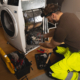 Repair person working on fixing a dryer