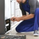 Male technician repairing refrigerator indoors