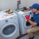 Side view of repairman working on washer and dryer units