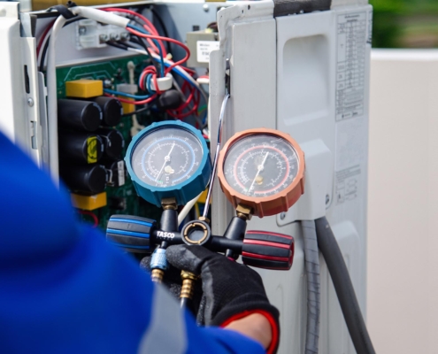 Person checking pressure on HVAC unit