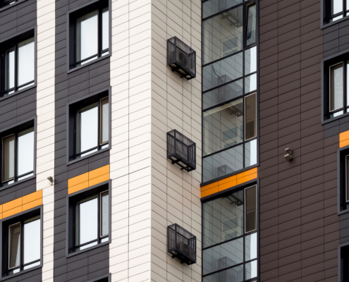 Fragment of a multi-storey house with windows, balconies